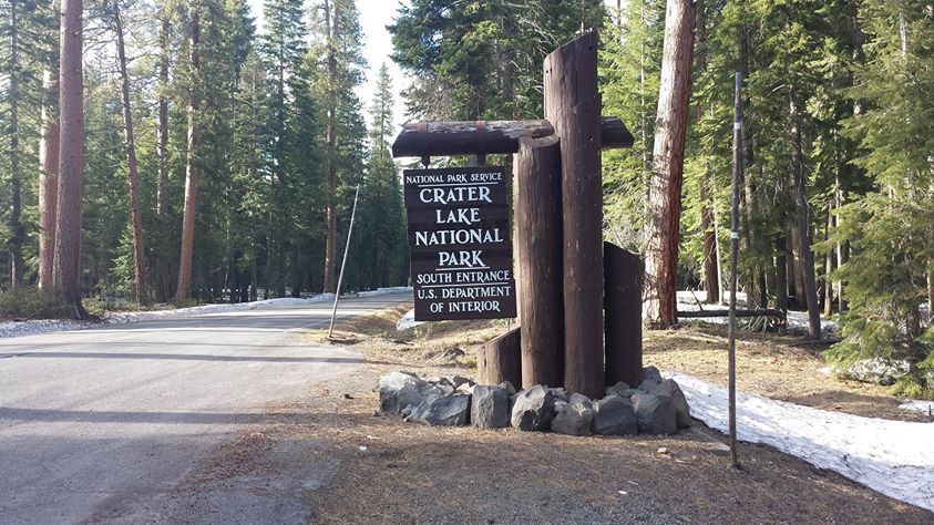 Sign at entrance to crater lake. Just a single patch of snow on the ground.