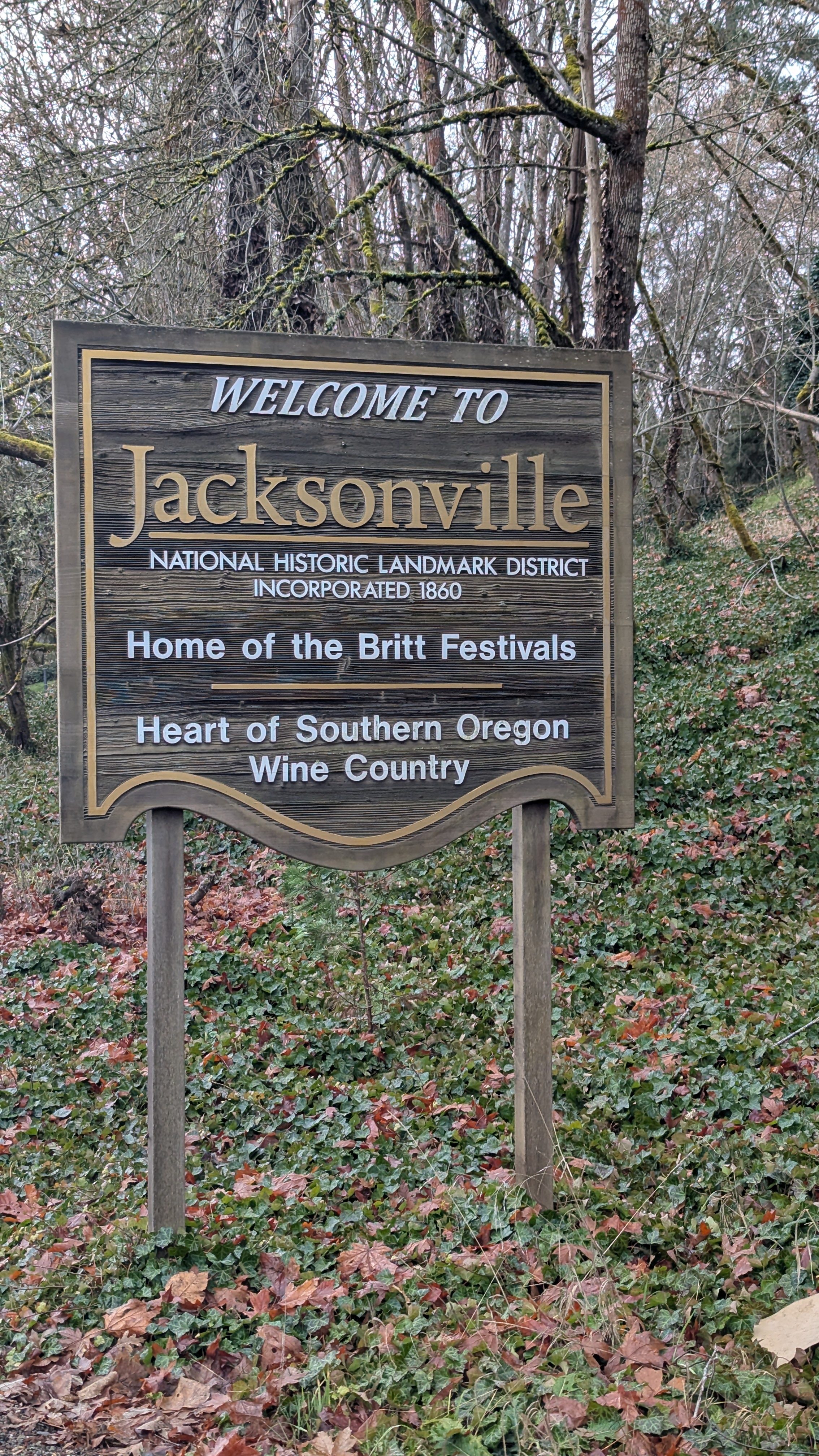 Jacksonville sign reading Welcome to Jacksonville, National Historic Landmark District, Incorporated 1860, Home of the Britt Festivals, Heart of Southern Oregon Wine Country.
