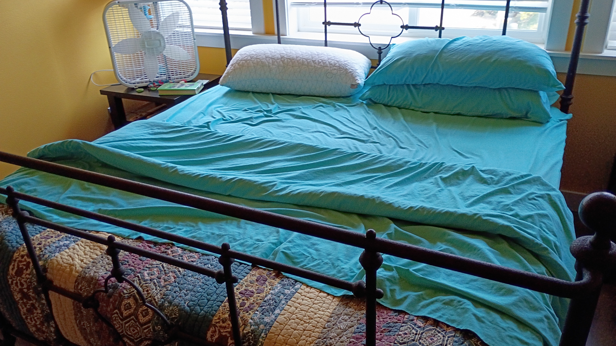 Bed cover and sheets formed into a breaking wave moving up the beach.