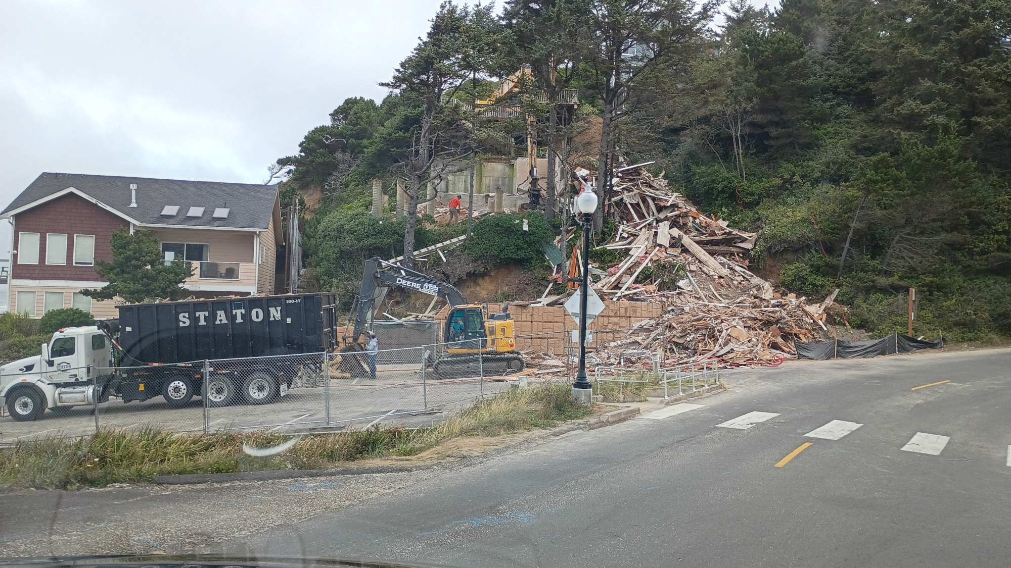 House built on a cliff overlooking the ocean being deconstructed because of ground shifting.