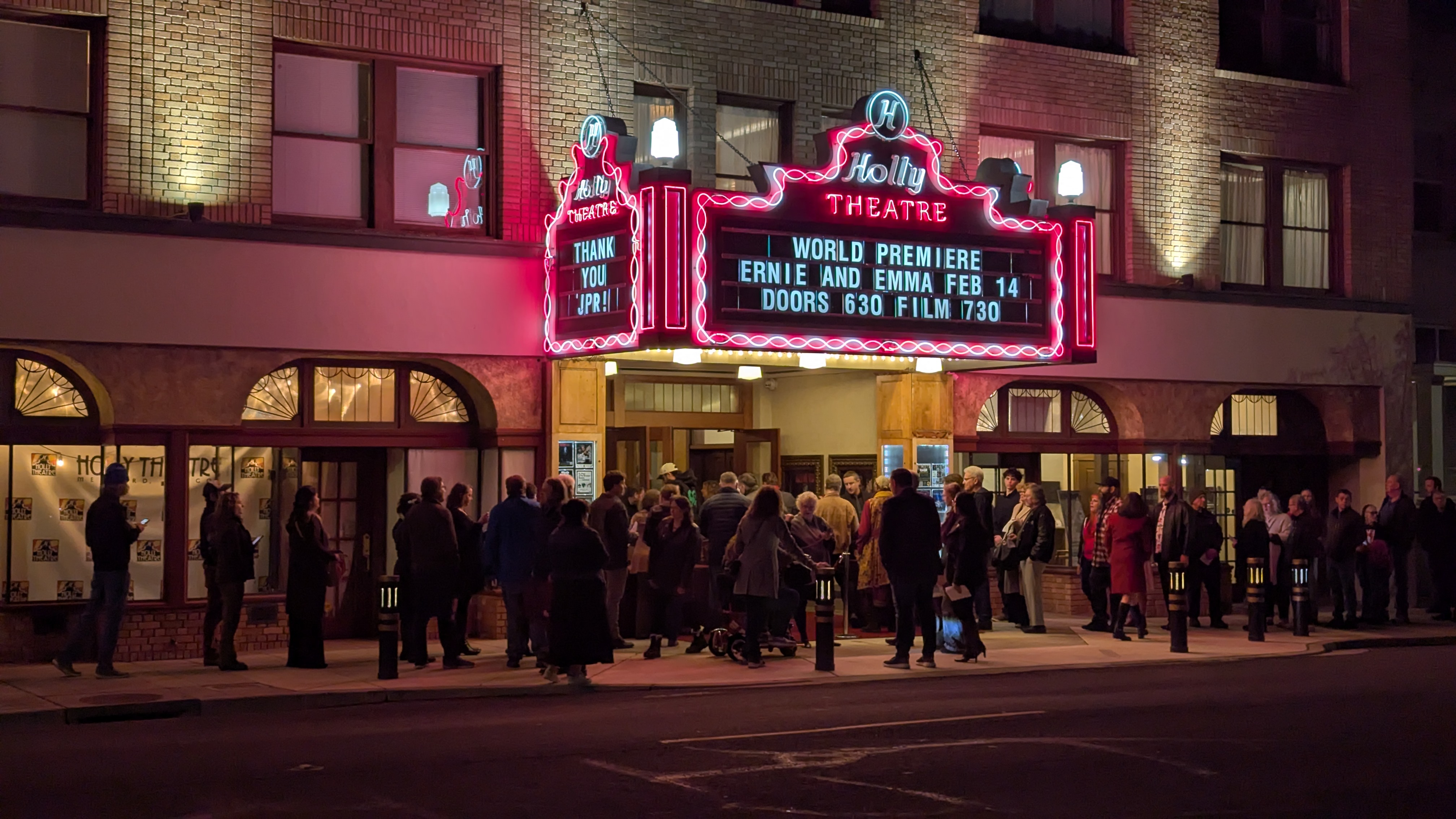 Holly Theatres' marquee at night. Sign reads, World Premiere, Ernie and Emma, Feb 14, Doors 6:30, Movie 7:30.