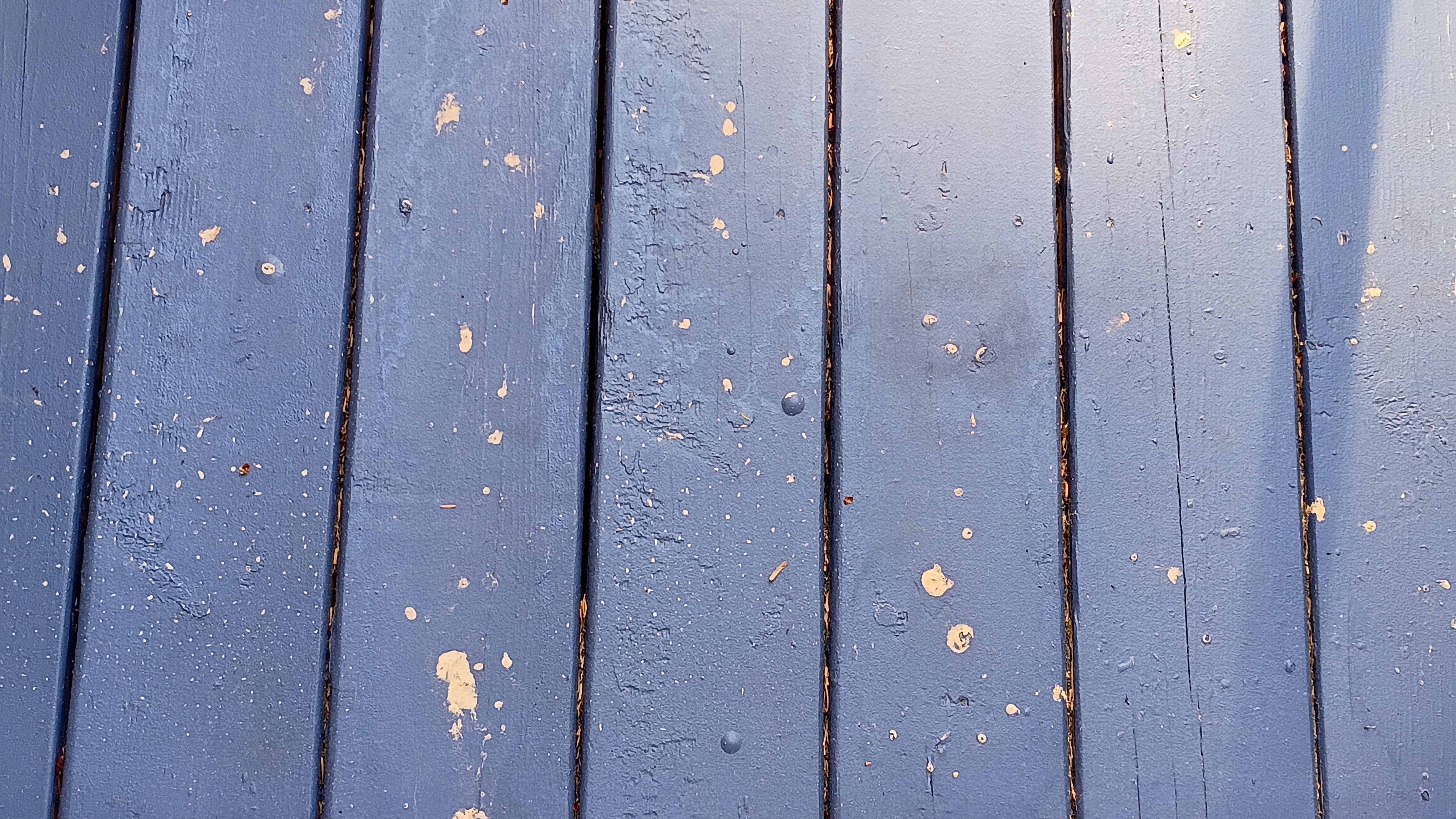 big and small chunks of yellow pollen on a blue deck.